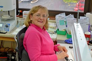 Dental lab technician smiling - communication between dentists and dental labs