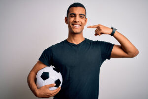 Sports dentistry - soccer player pointing at teeth